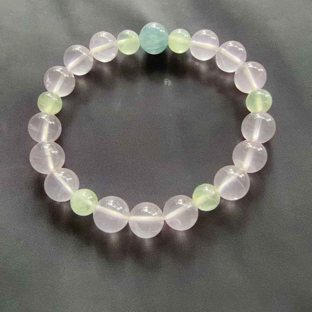 Rose quartz prehnite aquamarine bracelet laid flat showing the blue focal bead