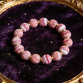 Rhodochrosite Women's 8mm natural stone bracelet on dark velvet